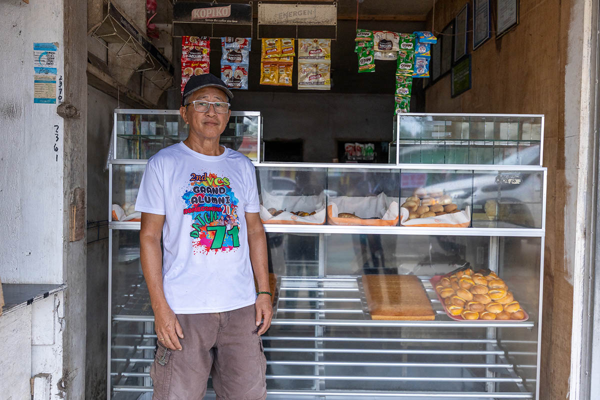 Lolito Eisola, one of the Micro Enterprise Resiliency Program (MERP) training participants, stands in front of his bakery stall.